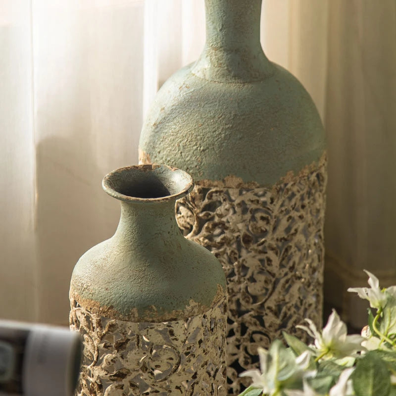 Two textured green vases with intricate patterns against a neutral background