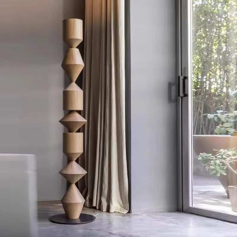 Decorative wooden sculpture in a modern interior setting with a window and plant.