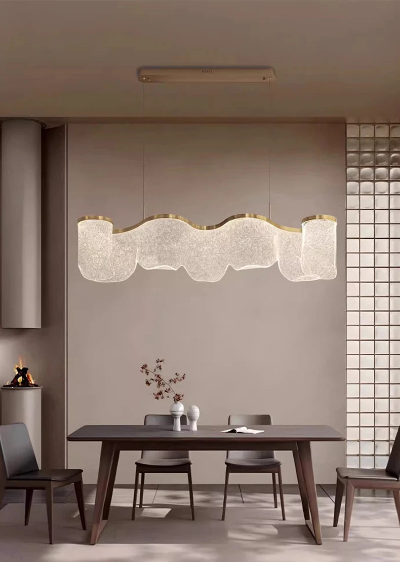 Modern dining room with a long, decorative ceiling light fixture.
