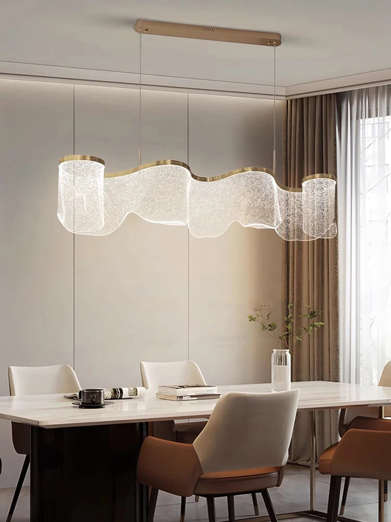 Modern dining room with a stylish chandelier, table, and chairs.
