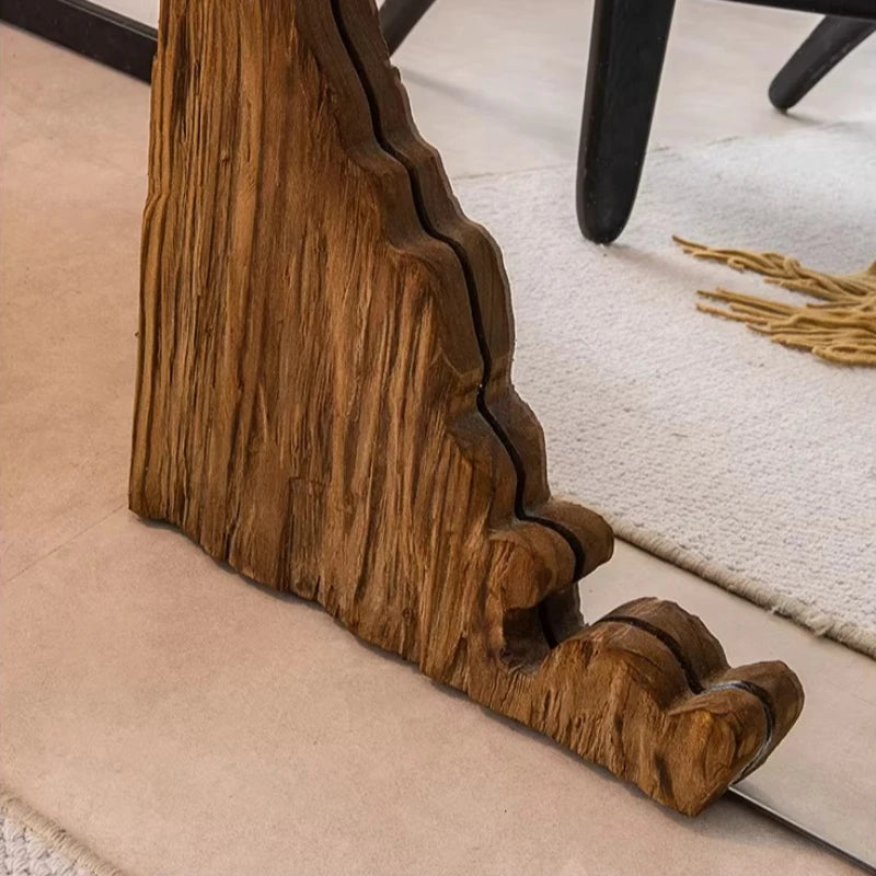 Close-up of a wooden leg with a textured surface on a carpeted floor.
