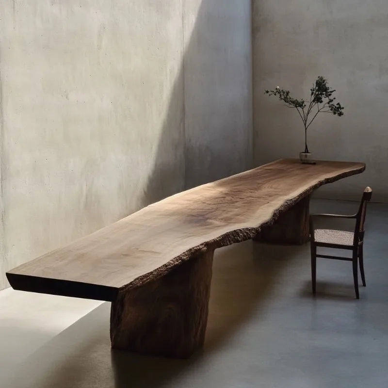 Long wooden table with natural edge design in a minimalistic room.