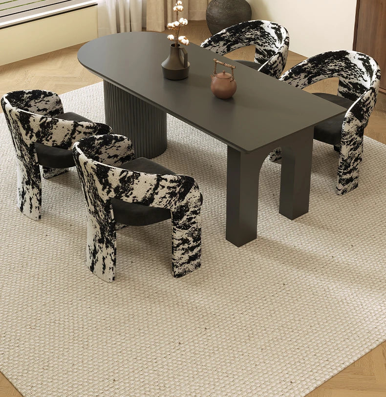 Dining table with four patterned chairs on a beige rug
