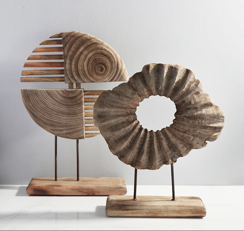 Wooden decorative items on stands with a plain background