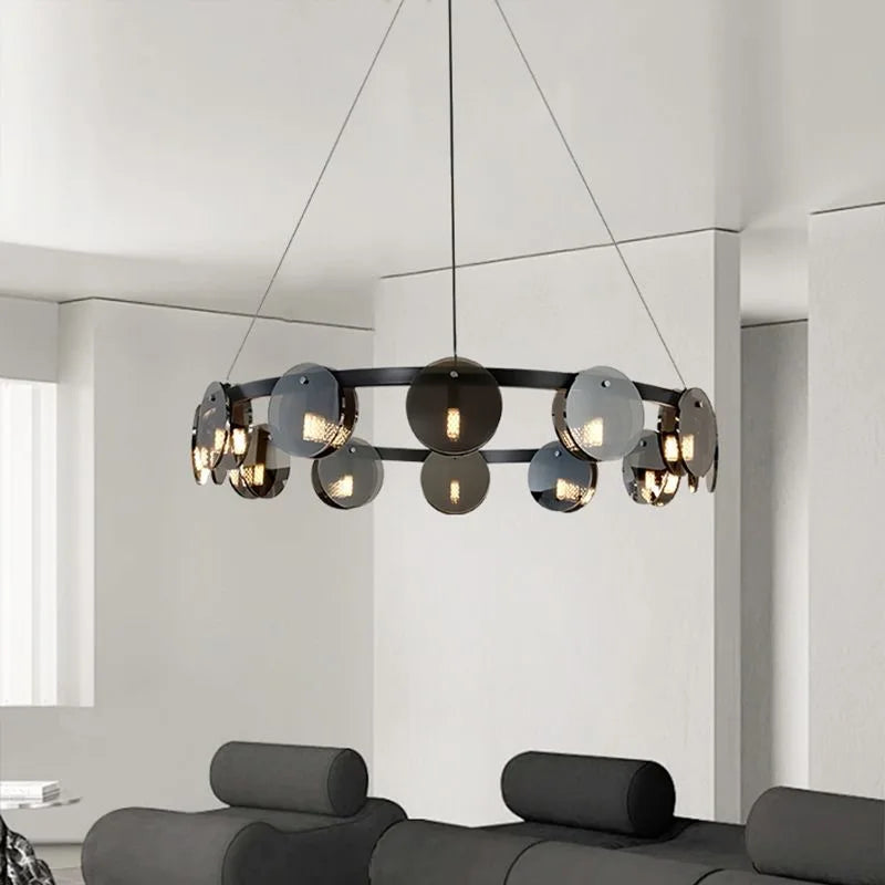Modern chandelier hanging in a room with a gray sofa and white walls.