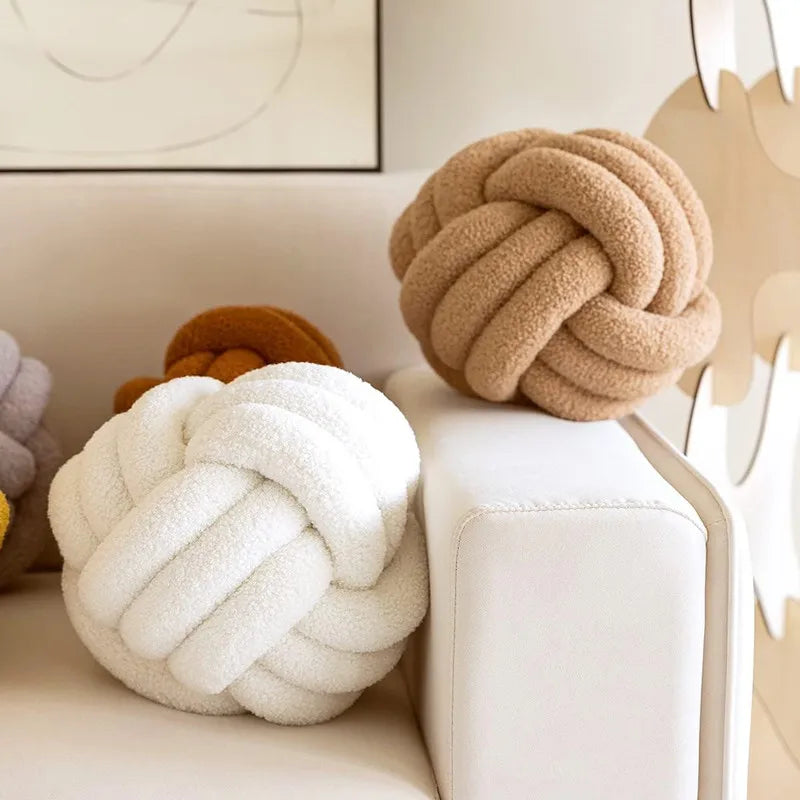 Soft handmade knot ball pillow with plush textured fabric placed on a modern sofa, stylish decorative cushion for cozy contemporary home décor.