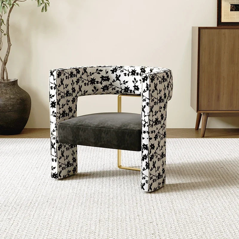 Chair with floral-patterned backrest and gray seat in a room with a plant and wooden cabinet.
