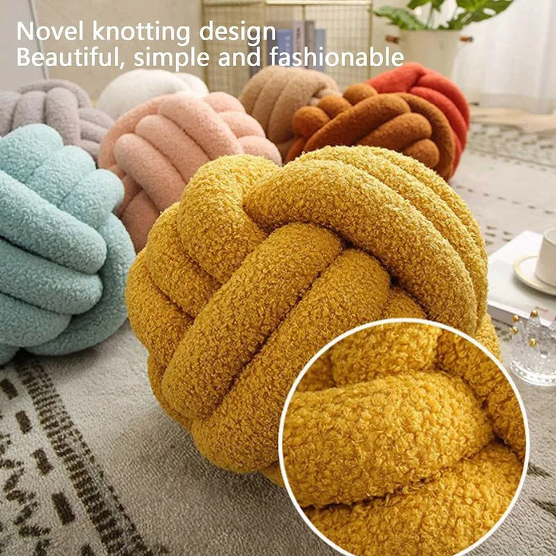 Novelty knot-shaped cushions in various colors on a surface.