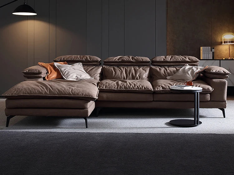 Brown sectional sofa in a modern living room setting with decorative pillows and a small table.