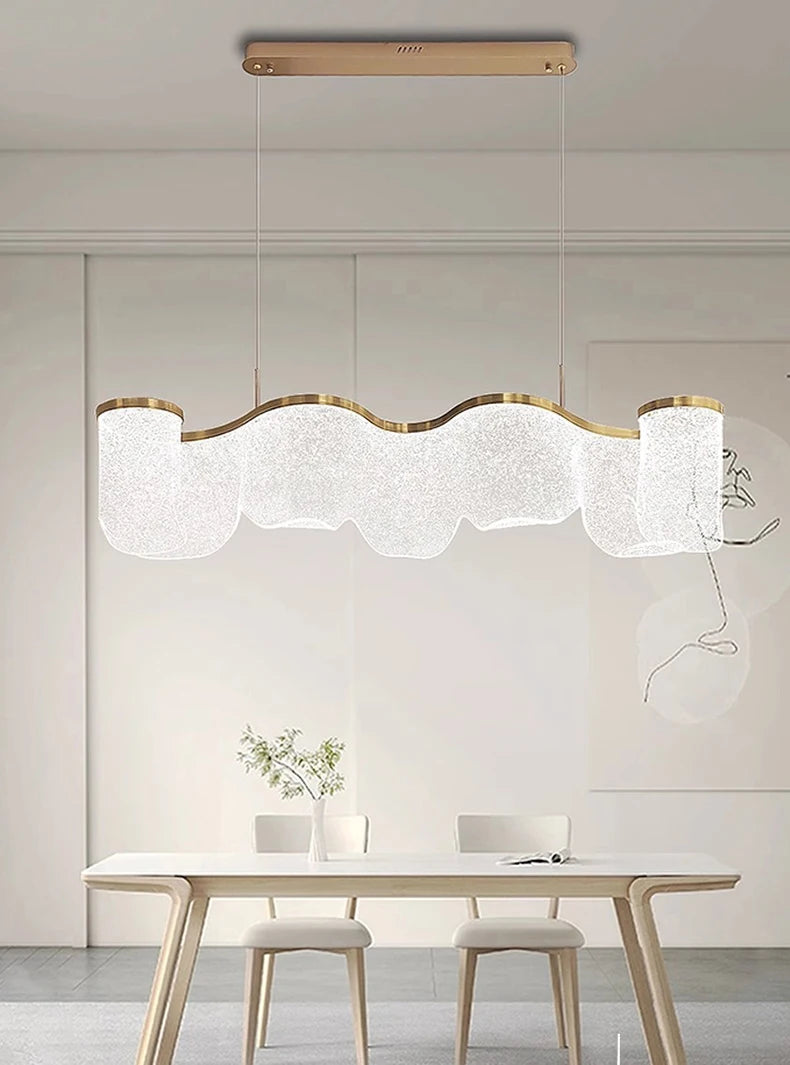 Modern pendant light hanging above a dining table with a minimalistic interior design.