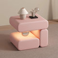 Pink side table with a lamp and decorative object on a neutral background