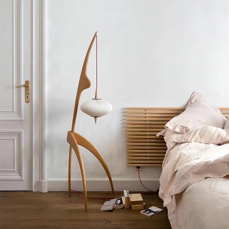 Modern bedroom with a unique wooden floor lamp and a bed with white bedding.