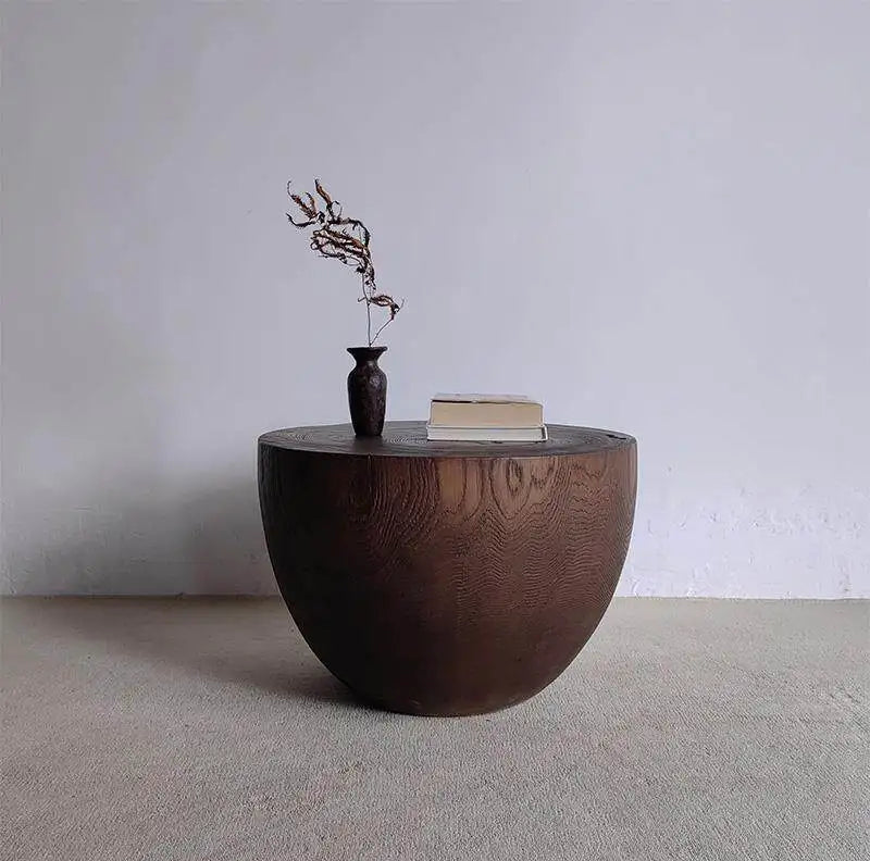 Wooden side table with a vase and book on a plain background