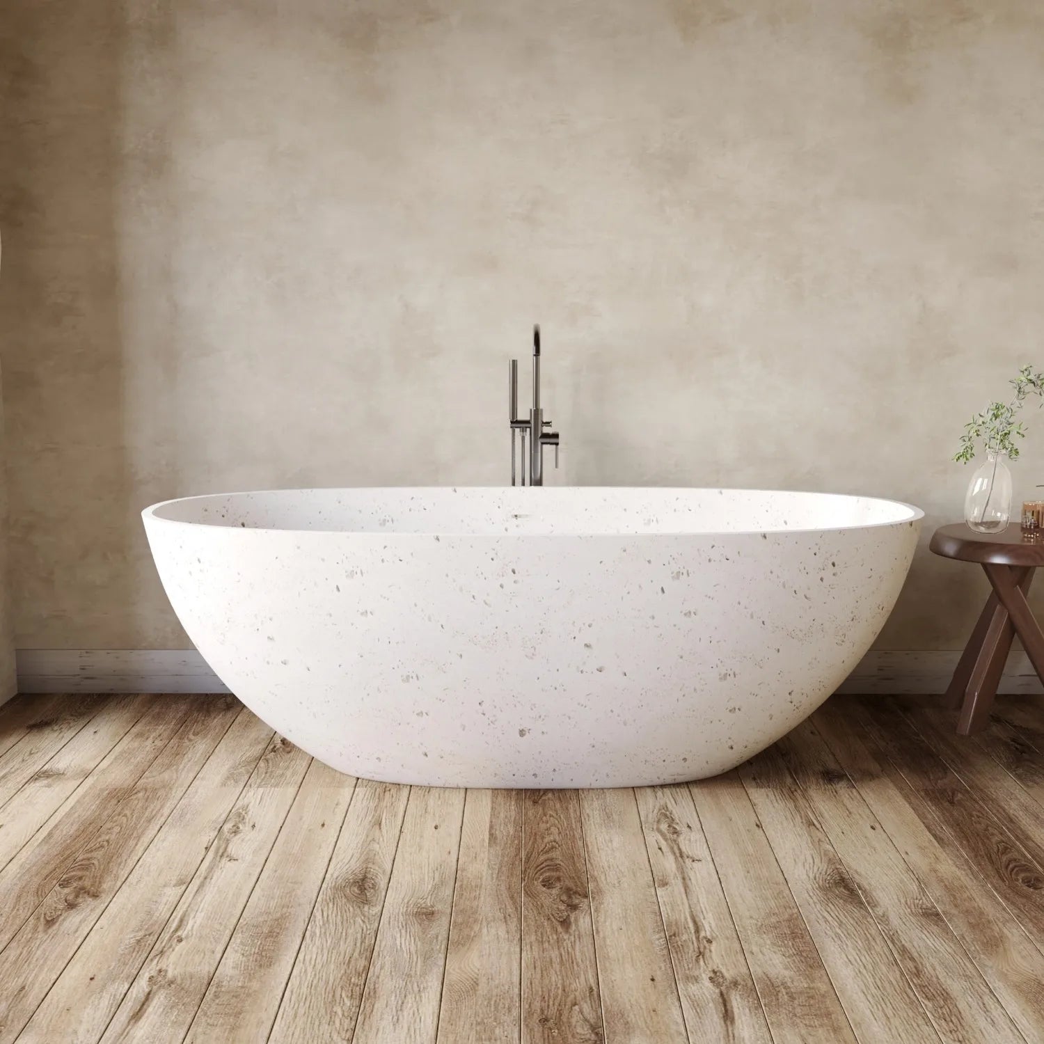 White freestanding bathtub in a bathroom with wooden floor and beige wall.