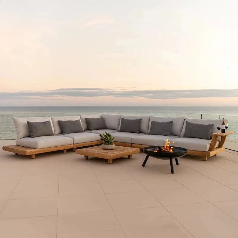 Outdoor patio furniture set with a fire pit on a deck overlooking water.