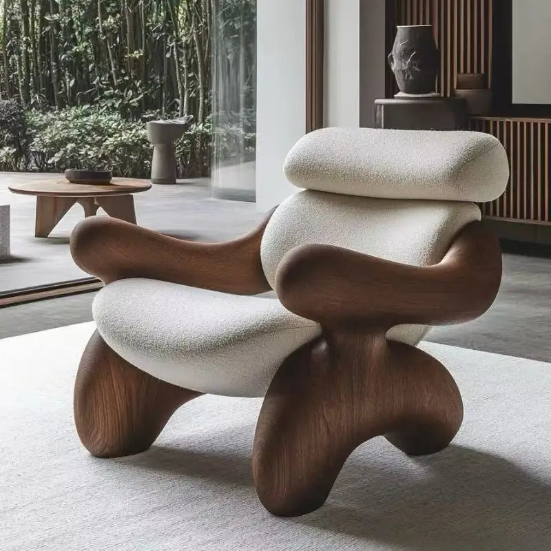Modern chair with wooden legs and white cushioned seat in a room with large windows.