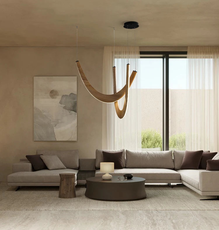 Modern living room with a chandelier, sofa, and large window.