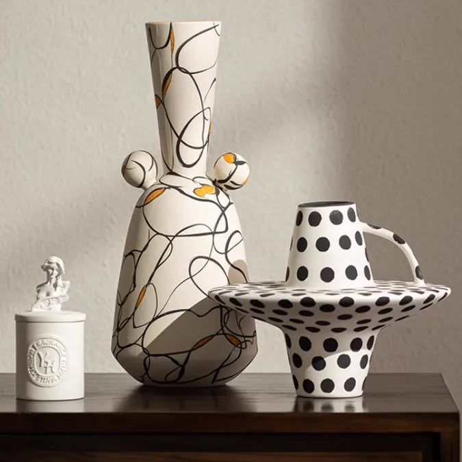 Three ceramic vases with unique designs on a wooden surface.