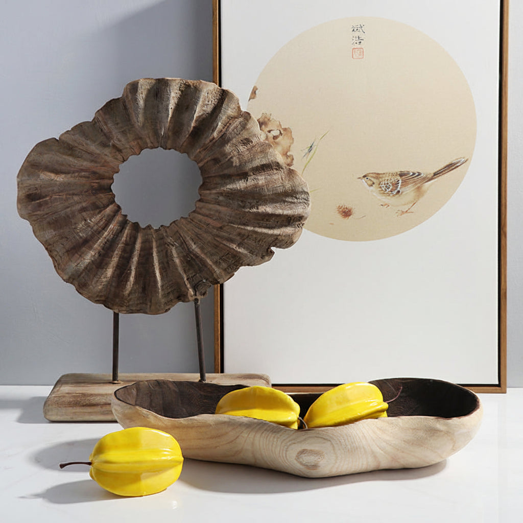 Decorative items including a wooden shell sculpture, a wooden bowl with yellow leaves, and a framed artwork on a white wall.