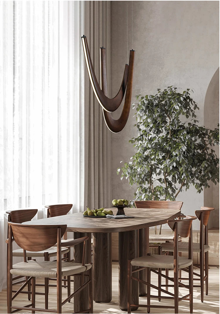 Dining room with wooden table and chairs, decorative plant, and modern wall art.
