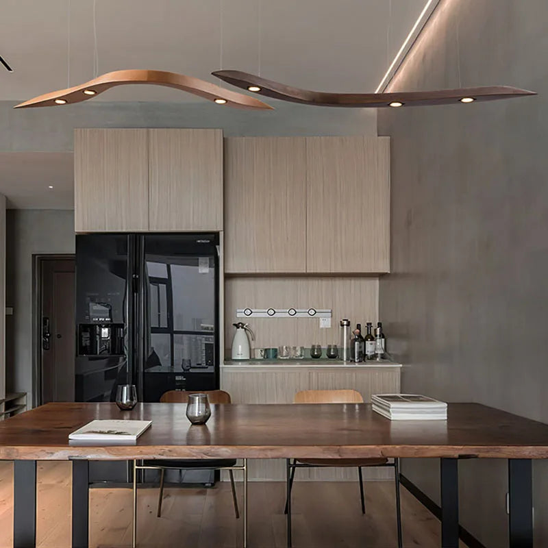 Modern kitchen with wooden dining table and stylish pendant lights.