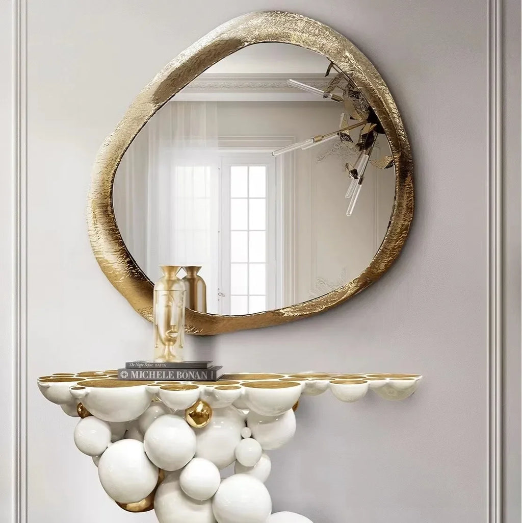 Decorative console table with spherical design and gold accents against a light gray wall.