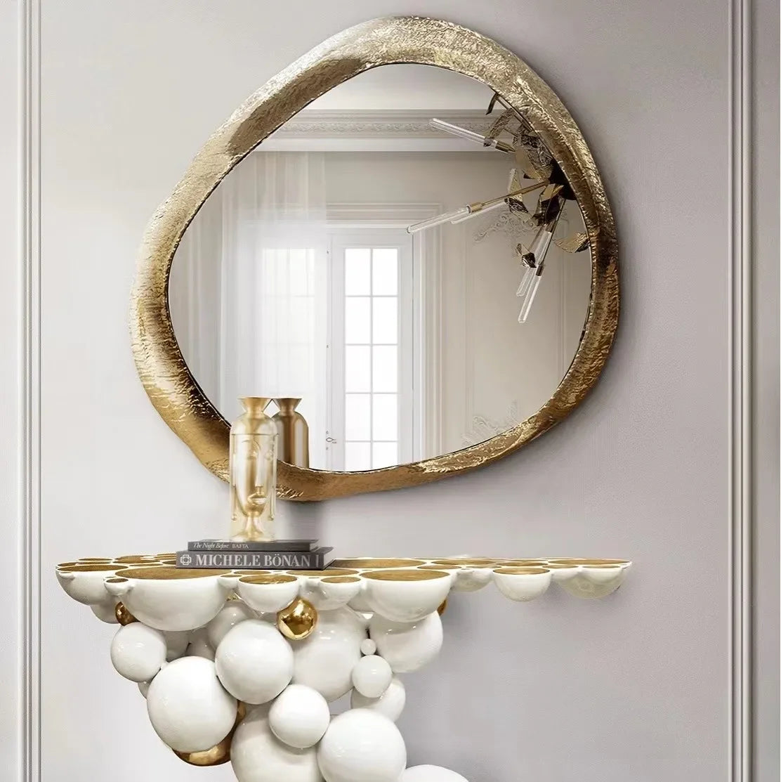 Decorative console table with spherical design and gold accents against a light gray wall.