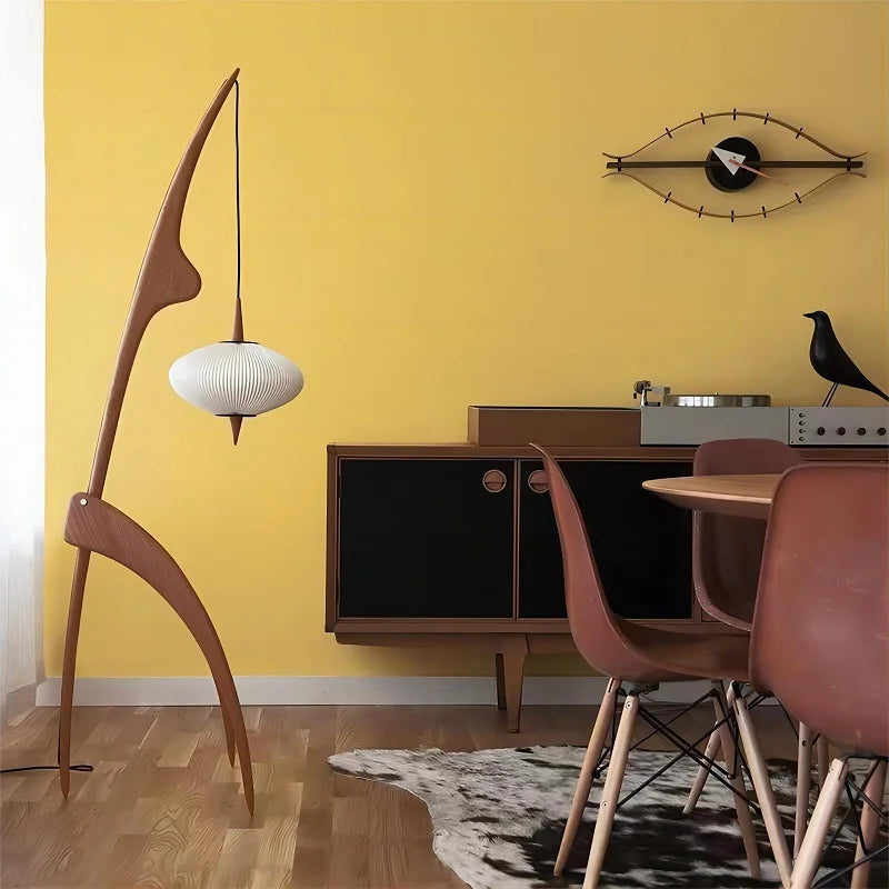 Modern interior with a yellow wall, wooden floor, and furniture including a lamp and chairs.