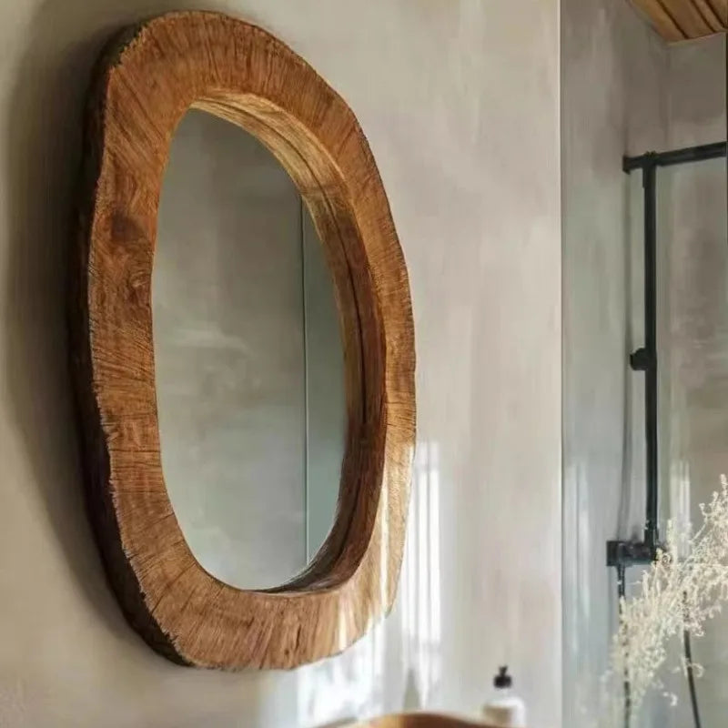 Wooden framed mirror on a wall with a blurred background