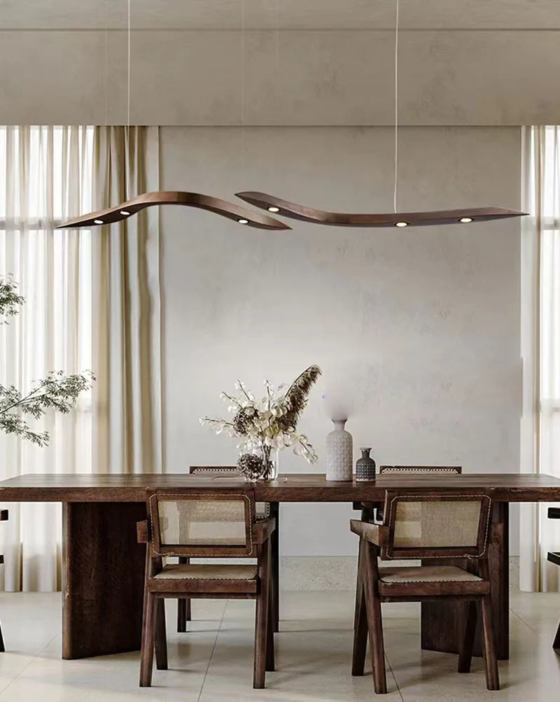 Dining room with wooden table and chairs, modern pendant lights, and decorative elements.
