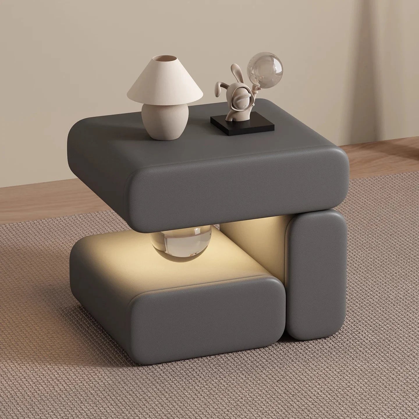 Modern gray side table with a lamp and decorative items on a wooden floor.
