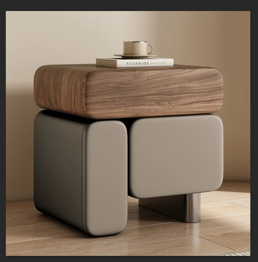 Wooden side table with a beige drawer against a neutral wall.