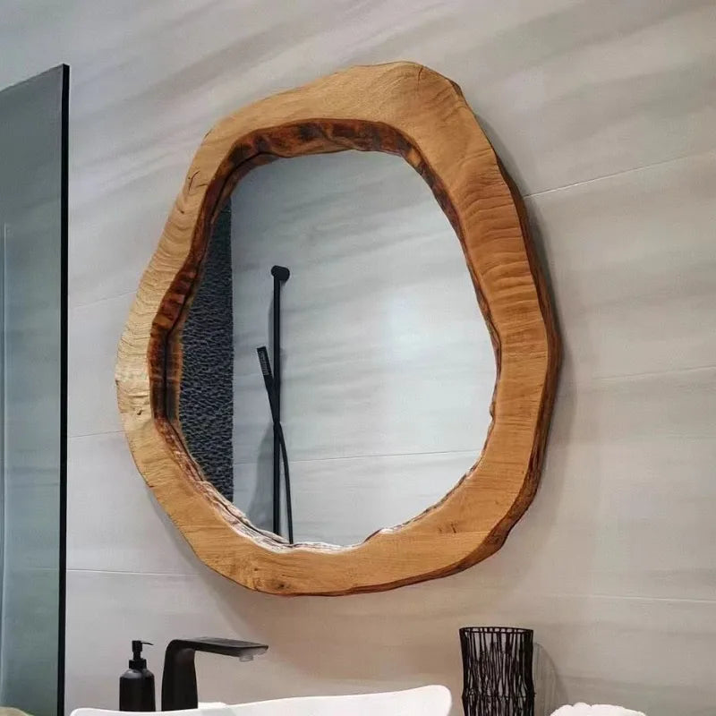 Wooden-framed mirror on a bathroom wall with a sink and faucet in the background.
