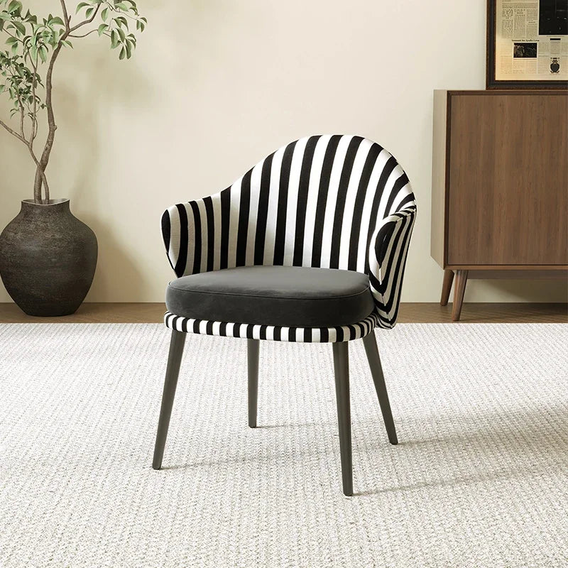 Black and white striped chair with a gray cushion in a room setting.