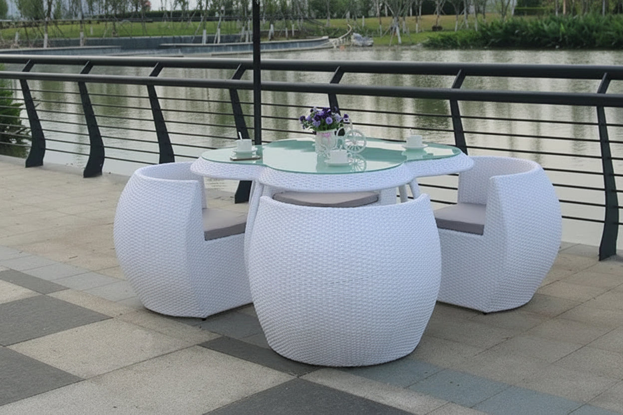 White outdoor furniture set with a table and chairs on a patio.