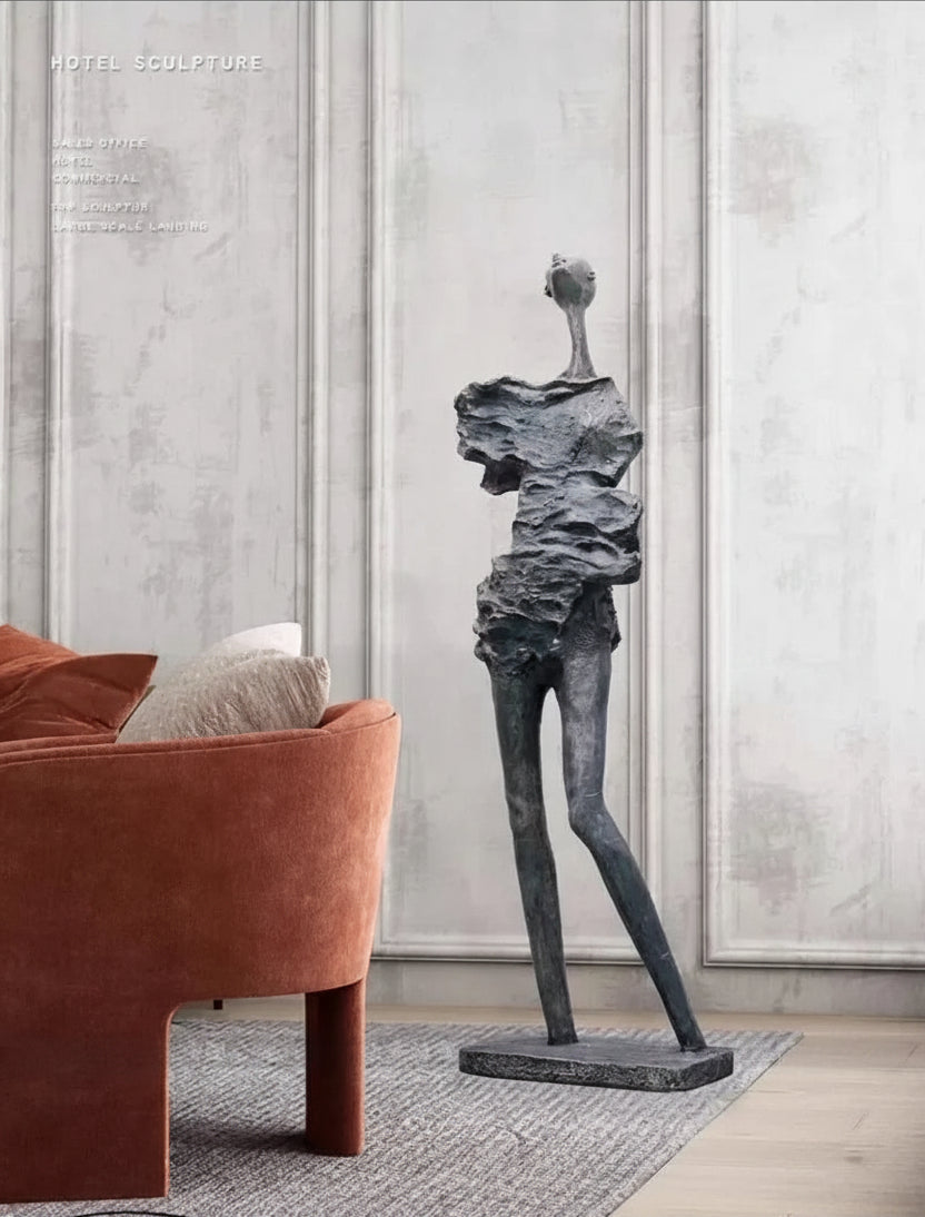 Modern interior with a sculpture and a brown sofa.