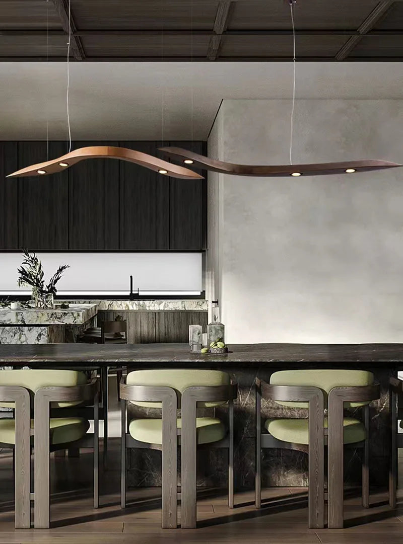 Modern kitchen with a long dining table and chairs, featuring stylish pendant lights.