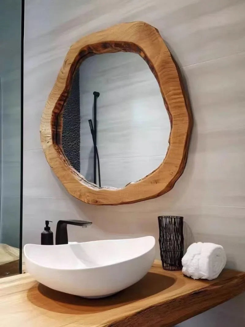 Bathroom vanity with a wooden mirror, white sink, and decorative items.