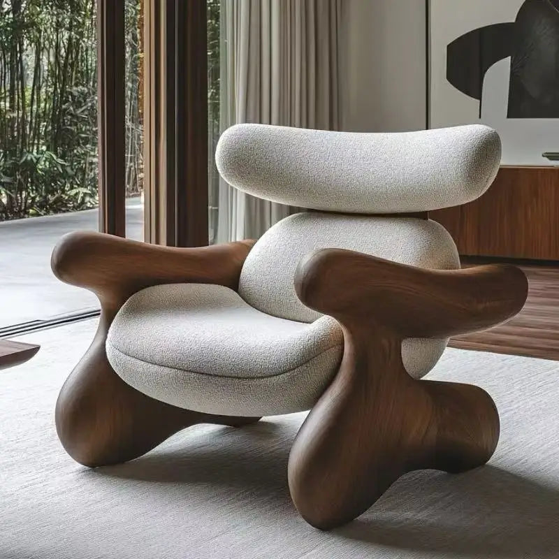 Modern chair with wooden legs and white cushioned seat in a room with large windows.