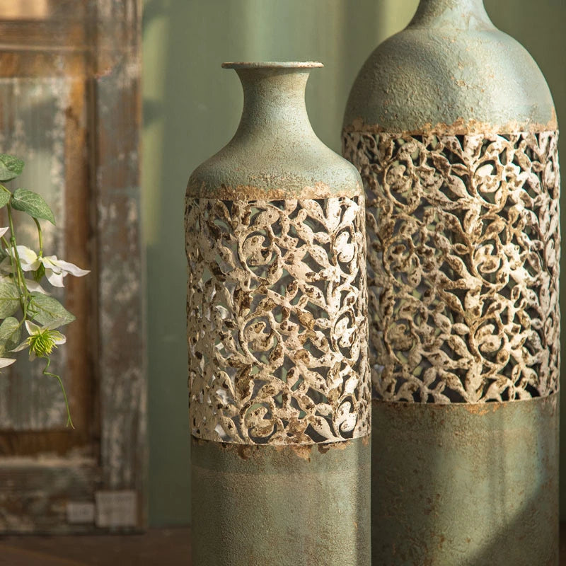 Two decorative vases with intricate cut-out patterns on a neutral background