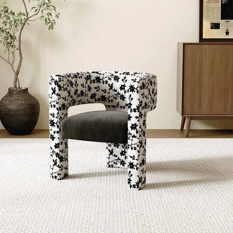 Chair with black floral pattern on a white background in a room setting.
