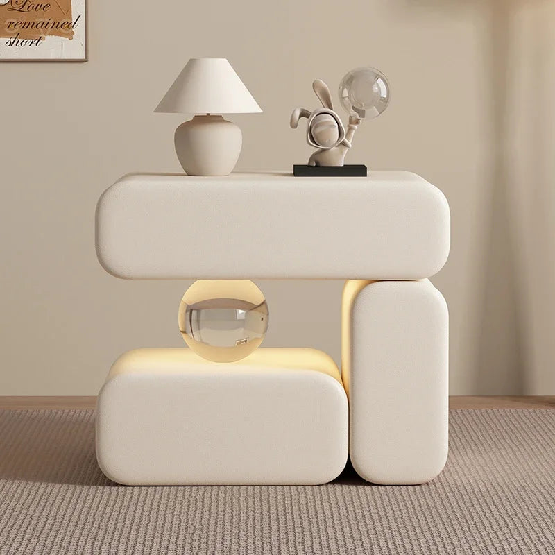 Modern white side table with decorative items against a beige wall.