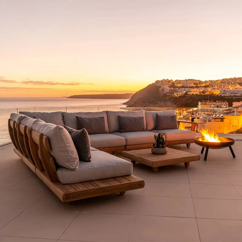 Outdoor patio set with a sectional sofa and fire pit table at sunset.