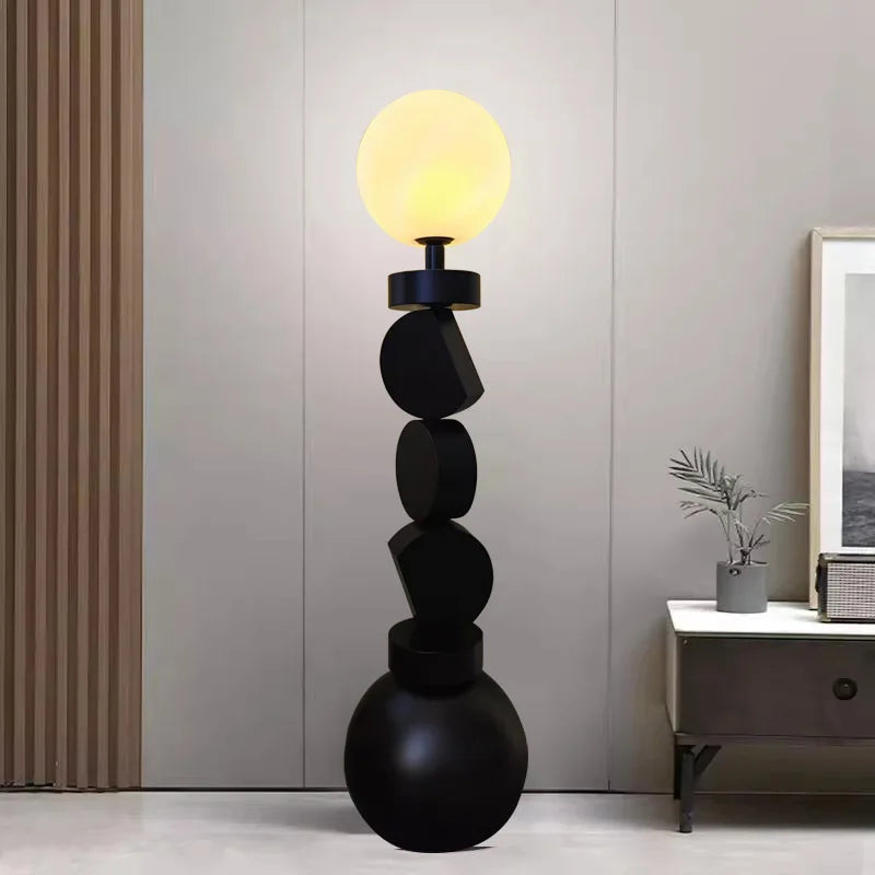 Modern black floor lamp with a yellow light bulb in a room setting.