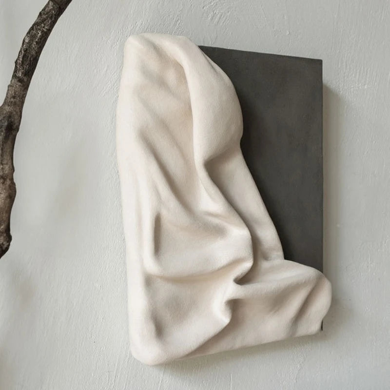 Abstract sculpture of a draped fabric on a neutral background