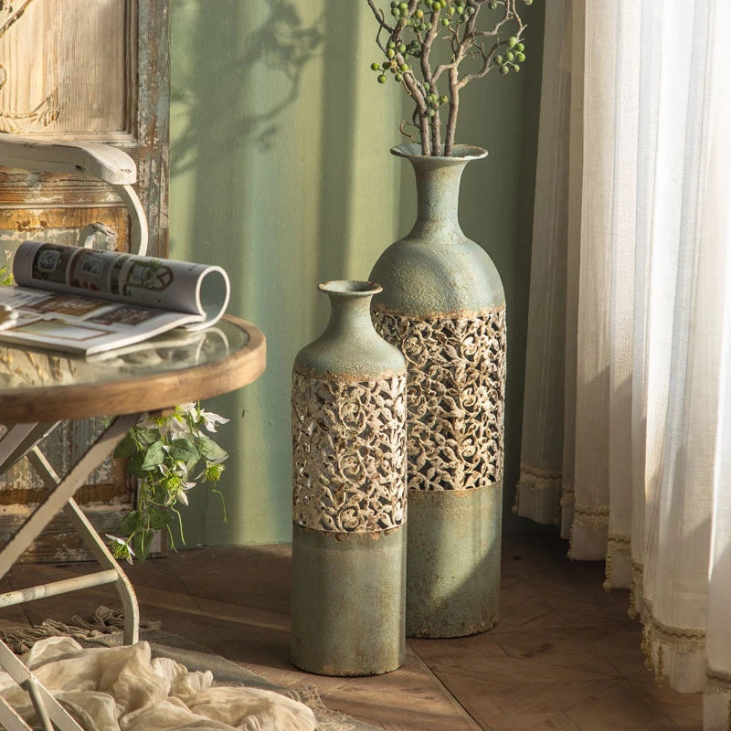 Two decorative vases with intricate patterns on a wooden floor next to a small round table.