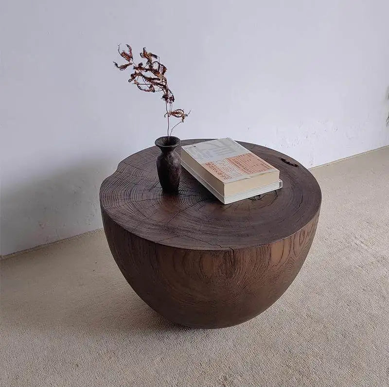 Wooden coffee table with a book and decorative item on a plain background