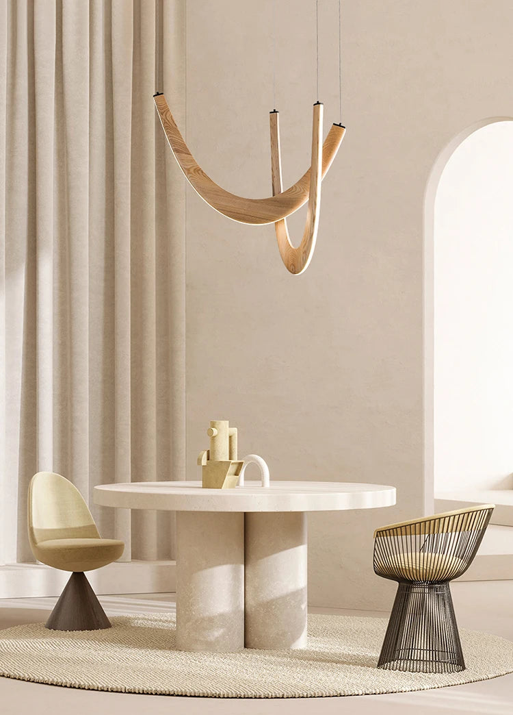 Modern dining room with a round table, chairs, and a hanging light fixture.