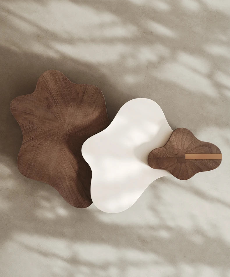 Two wooden leaf-shaped coasters on a textured surface with soft shadows.