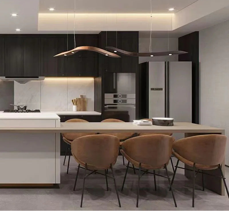 Modern kitchen with black cabinets, white countertops, and brown chairs.